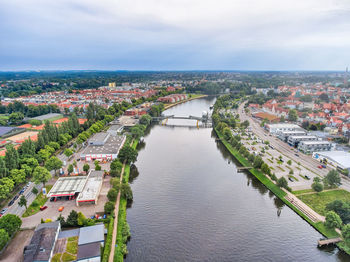 High angle view of river amidst buildings in city against sky