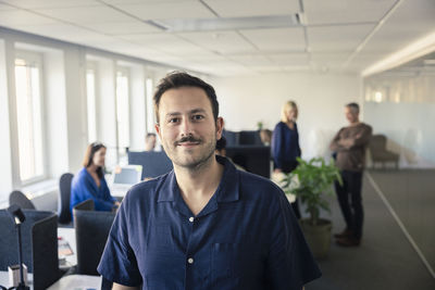 Portrait of team leader standing in office