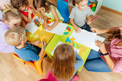 High angle view of people sitting on table