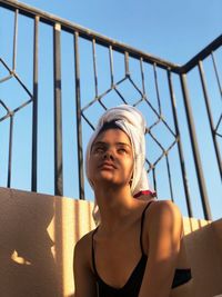 Low angle view of woman with towel on head sitting outdoors