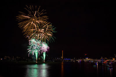 Firework display over river at night