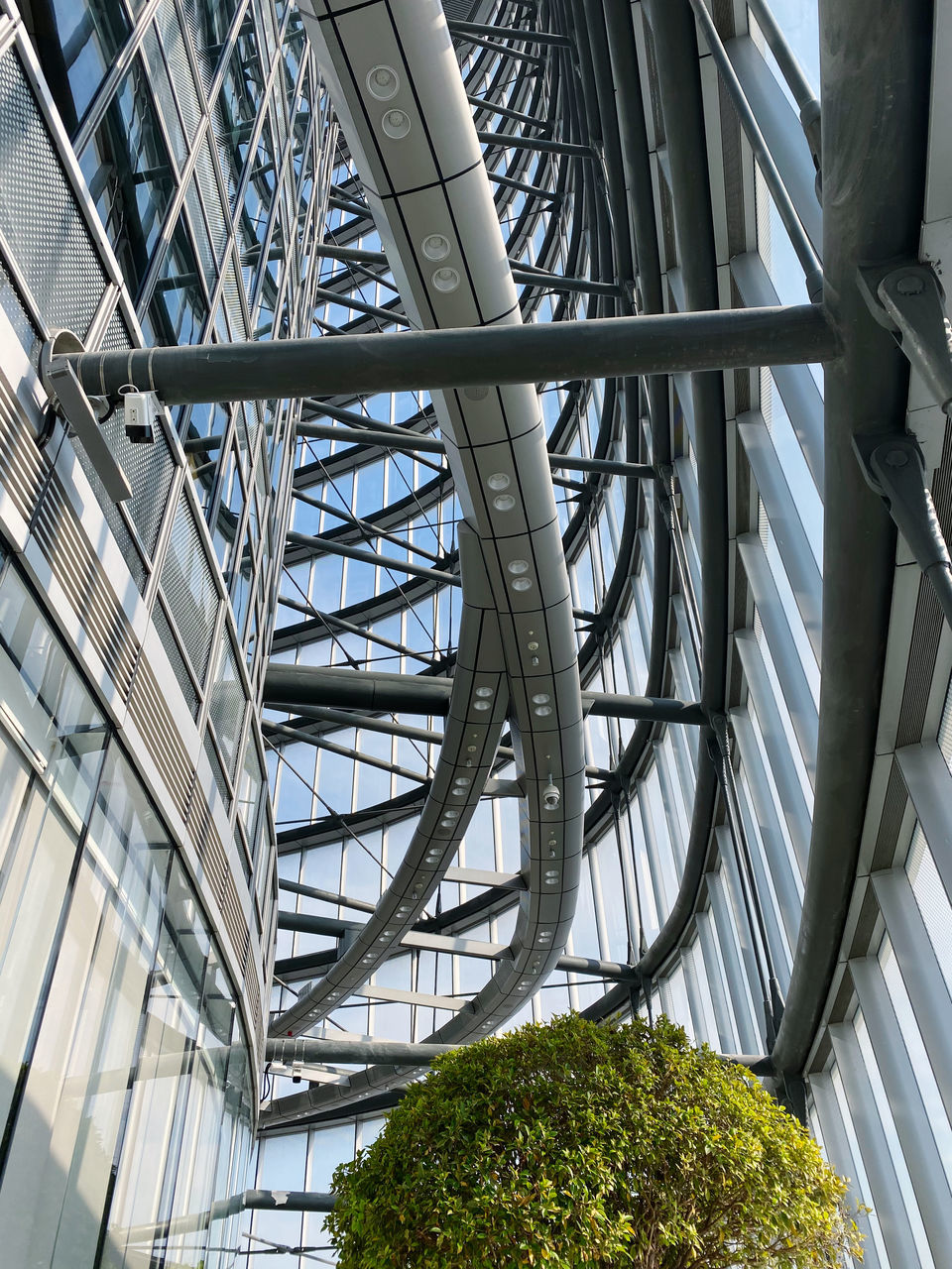 LOW ANGLE VIEW OF METAL BRIDGE AND PLANTS IN BUILDING