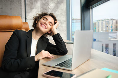 Young businesswoman using laptop at office