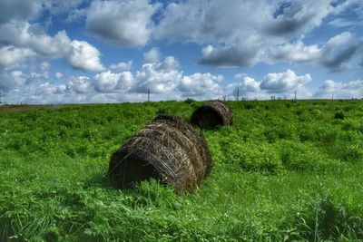 Hay bales on field against sky