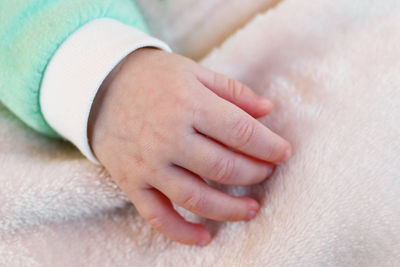 Cropped hand of child on blanket