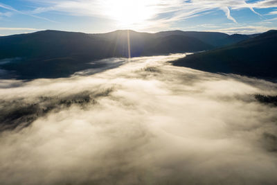 Aerial drone view of morning mist and low cloud over mountain forest