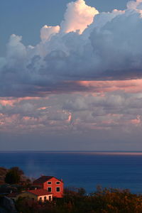 Scenic view of sea and buildings against sky during sunset