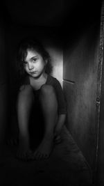 Portrait of serious girl sitting in darkroom