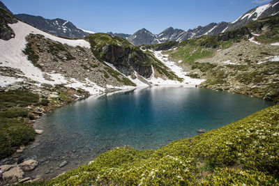 Scenic view of lake and snowcapped mountains against sky