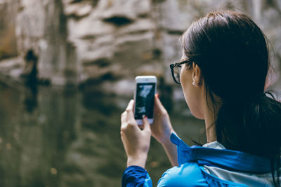 Rear view of woman photographing outdoors