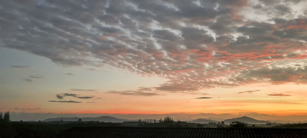 Scenic view of dramatic sky over silhouette landscape