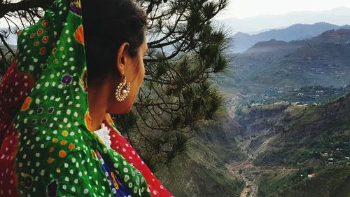 Woman in traditional clothing overlooking landscape