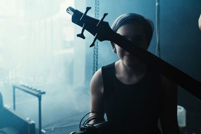 Woman holding camera while sitting on stage