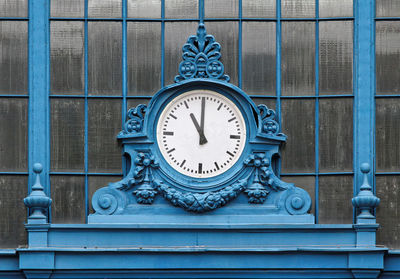 Close-up of blue clock against window