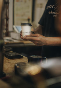 Close-up of hand holding coffee cup