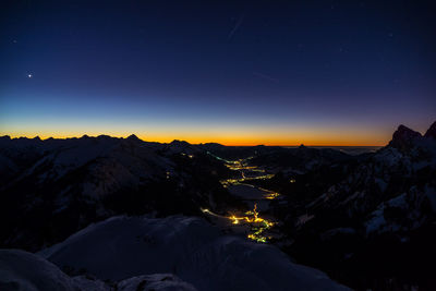 Scenic view of snowcapped mountains against sky at night