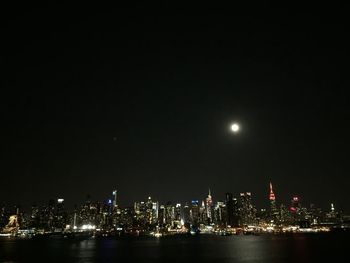 Illuminated buildings against sky at night