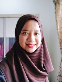 Close-up portrait of smiling woman at home