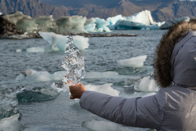 Female hand pointing out towards jökulsárlón glacier lagoon in iceland