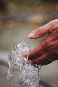 Cropped hand by spraying water