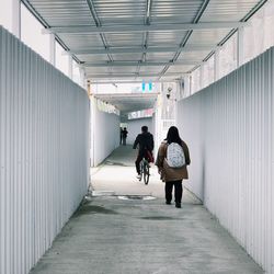 Rear view of people standing in corridor