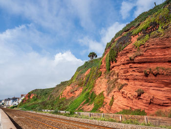 Scenic view of road by mountains against sky