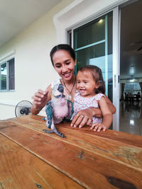 Happy mother and daughter with an macaw at home