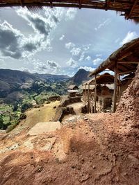 View of abandoned buildings against cloudy sky