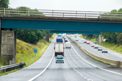 Vehicles on road bridge against sky