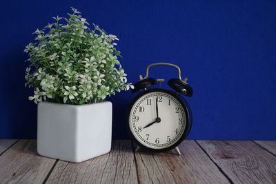 Close-up of alarm clock on blue background