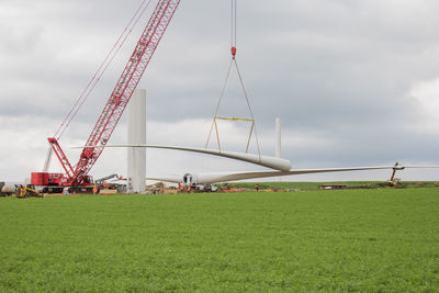 Cranes at construction site against sky