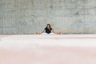 Athlete stretching while exercising against wall