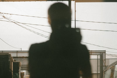 Shadow of person standing on railing against wall