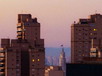 Buildings in city against sky during sunset