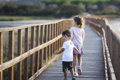 Full length of young woman walking on footbridge