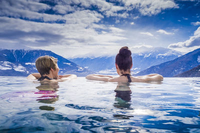 Rear view of friends swimming in pool