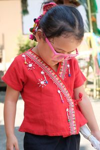 Full length of woman holding red while standing outdoors