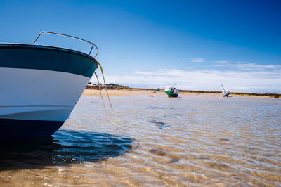 Sailboat moored on sea against sky