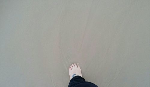 Low section of person standing on tiled floor