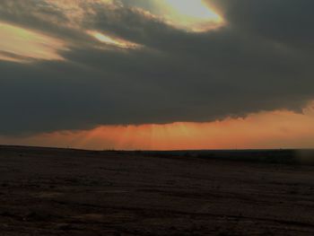 Scenic view of seascape against cloudy sky during sunset