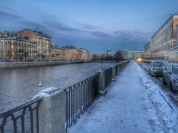 River amidst cityscape against sky