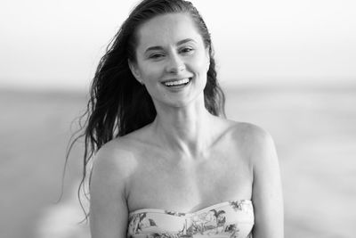 Portrait of a smiling young woman against sea