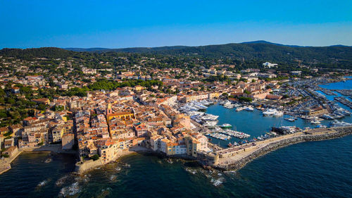 High angle view of townscape by sea against sky