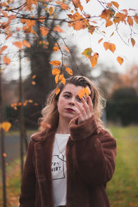 Portrait of young woman with autumn leaves