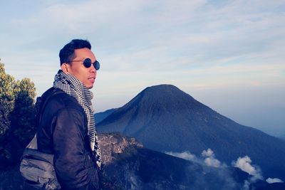 Man standing on mountain against sky