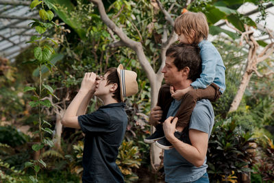 Adventurous family inspecting tropical gallery in botanical garden. local travel