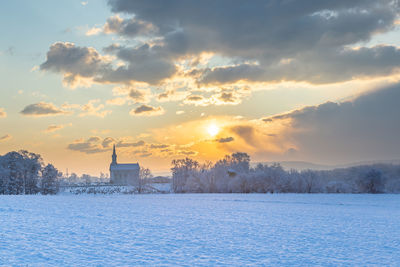 Scenic view of snow field against sky during sunset