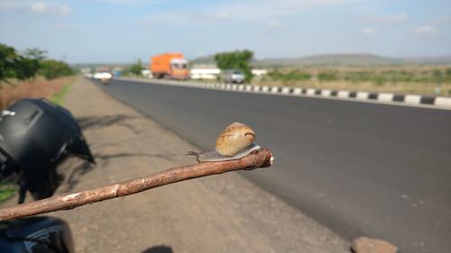 Close-up of rusty metal on road against sky