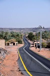 Road by landscape against clear sky