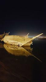 Airplane flying over sea against clear sky at night